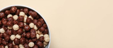 Bej arka planda lezzetli çikolatalı mısır topları ve metin için yeri olan bir kase