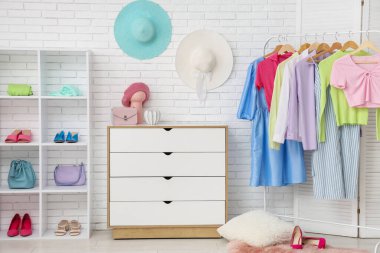 Askısı, çekmecesi ve raf ünitesi olan şık bir soyunma odası.