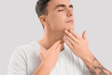 Genç adam arka planda yüz geliştirme egzersizi yapıyor.