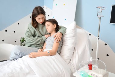 Enfüzyon serumlu tatlı bir kız ve annesi hastane odasında.