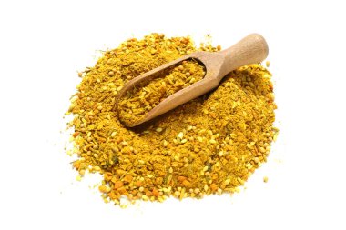 Beyaz arka planda bir yığın aromatik köri ve ahşap kepçe