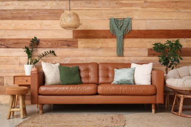 Oturma odasının içinde rahat bir kanepe, koltuk ve puf.