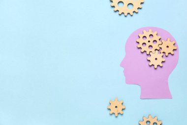 Mavi arka planda ahşap dişliler olan kağıt insan kafası. Mantık kavramı