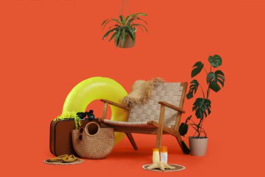 Çantalı koltuk, şişirilebilir yüzük, güneş kremi ve turuncu arka planda plaj aksesuarları. Tatil kavramı