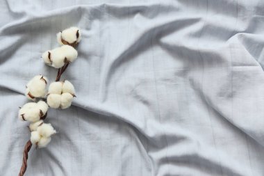 Yatak odasındaki temiz çarşafta pamuk çiçekleri filizlenir.