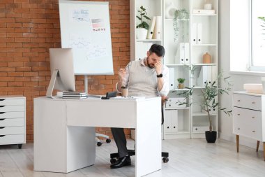 Ofiste oturan yorgun işadamı.