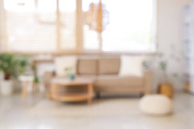 Gri kanepeli, masalı ve pencereli oturma odasının bulanık görüntüsü