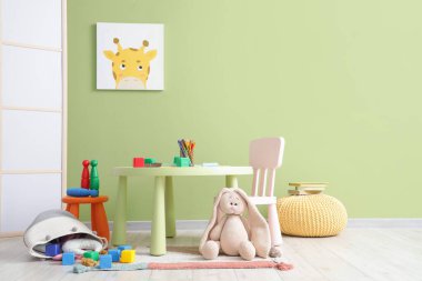 İçinde masa ve oyuncaklar olan dağınık çocuk odası.