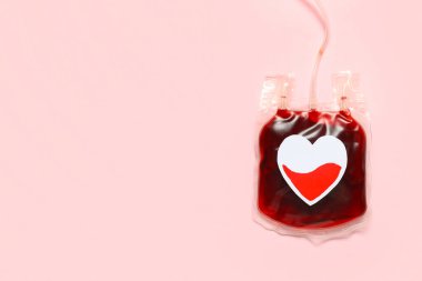 Pembe arka planda kağıt kalp nakli için kan torbası. Kan bağışı konsepti