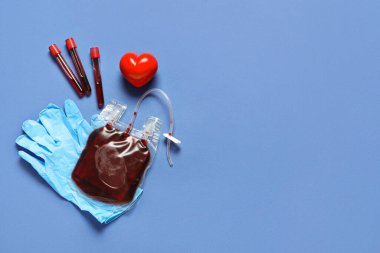 Kan nakli için mavi arka planda test tüpleri, eldivenler ve kırmızı kalp. Kan bağışı konsepti