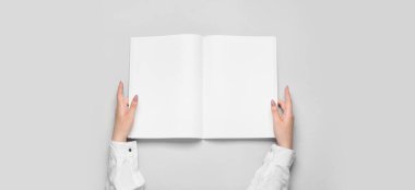 Açık arkaplanda boş broşür tutan eller 