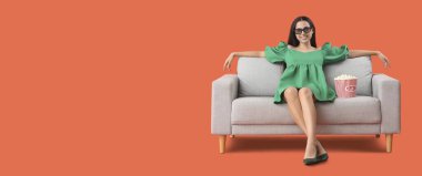 Üç boyutlu gözlüklü, patlamış mısırlı genç bir kadın kanepesinde turuncu arka planda film izliyor ve mesaj için yeri var.