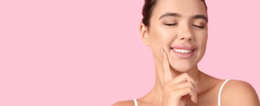 Pembe arka planda güzel dudakları olan genç bir kadın.