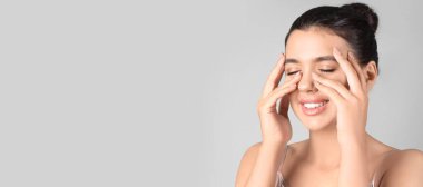 Gri arkaplanda güzel dudakları olan genç bir kadın.