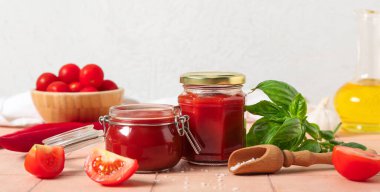 Kavanozlar dolusu lezzetli ketçap ve malzemeler masada.