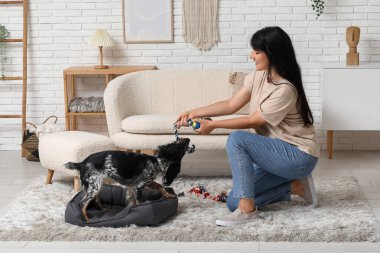 Evde köpeğiyle oynayan bir kadın.
