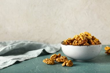 Masanın üzerinde beyaz duvara karşı bir kase lezzetli ceviz