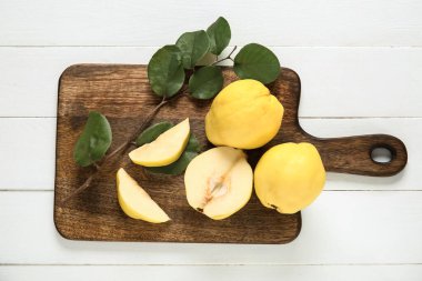 Tatlı olgun ayva ve beyaz ahşap arka planda yaprakları olan tahta.