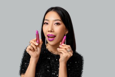 Gri arkaplanda ruj izi olan güzel Asyalı kadın.