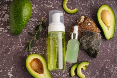 Taze avokado ve grunge arkaplanda gerekli yağ şişeleriyle kompozisyon