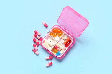 Renk arkaplan üzerinde farklı haplar bulunan pembe bir kap