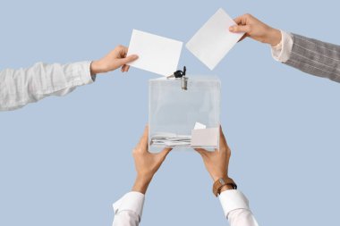 El, oy pusulasını arka plandaki sandığa koyuyor. Seçim kavramı