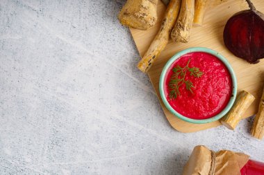 Kavanozda pancar sosu ve gri masada pancar sosu. Üst görünüm