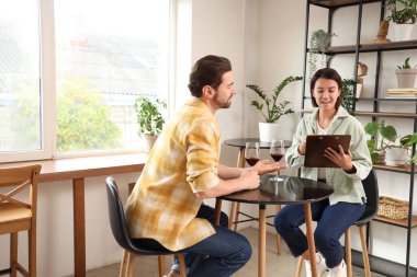 Kafede menü okuyan genç bir çift.