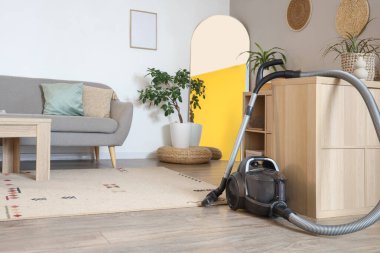 Oturma odasındaki klozetin yanındaki elektrikli süpürge.