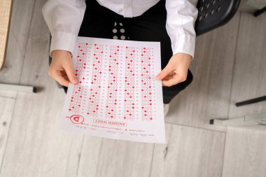 Sınav sonuçlarıyla sınıfa oturan tatlı bir okul çocuğu.