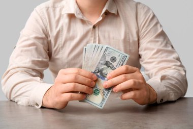 Masada açık arkaplanda dolar banknotları olan adam, yakın plan.