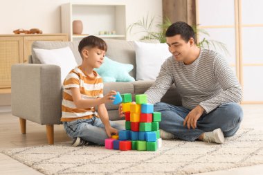 Mutlu baba ve küçük oğlu evde küplerle oynuyorlar.