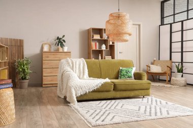 Rahat bir kanepe, sandık dolusu çekmece ve oturma odasının içindeki kitaplıklar.