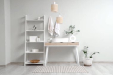 Rafla kaplı banyo ve beyaz duvarın yanındaki masa bulanık görünüyor.