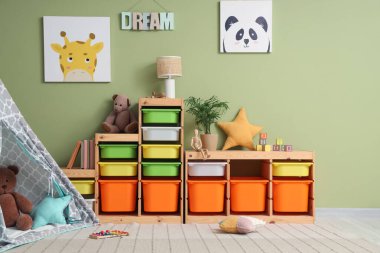 Raf üniteli çocuk odasının içi ve yeşil duvarın yanında çadır.