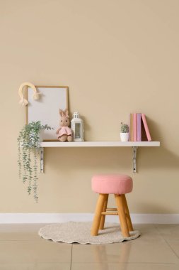 Rafı ve taburesi olan çocuk odasının içi.