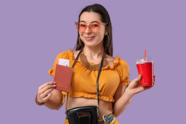 Pasaportu ve leylak arka planda kokteyli olan genç bir bayan turist.