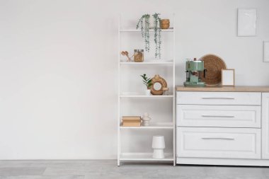 Beyaz tezgahlı, kahve makineli ve raflı şık bir mutfak.