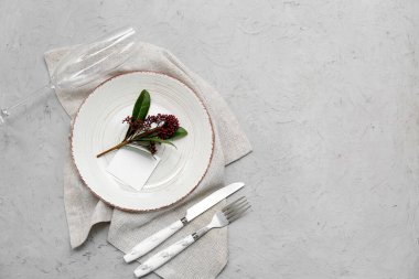 Boş kart ve gri arka planda skimmia japonica bitkisi olan güzel masa ayarları