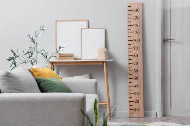 Kanepesi, çiçekleri, ahşap stadyumu ve masa dekoru olan modern oturma odasının içinde.