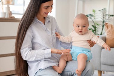 Genç, mutlu bir anne ve tatlı küçük kızı evde yerde oturuyor.