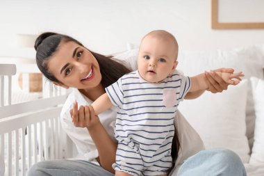 Güzel, genç, mutlu bir anne ve tatlı küçük kızı evdeki beşiğin yanında yatıyorlar.