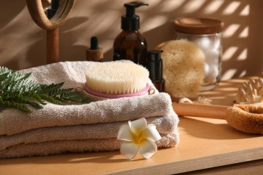 Spa aksesuarları, kozmetik ürünleri ve ahşap masada eğreltiotu yaprağı olan kompozisyon