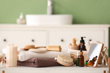 Banyoda farklı banyo malzemeleri, kozmetik ürünler ve aynalar var.