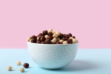 Renkli arkaplanda lezzetli çikolatalı mısır topları olan kase