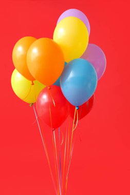 Kırmızı arkaplanda renkli hava balonları