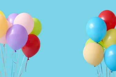 Mavi arka planda bir sürü renkli hava balonu