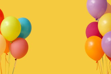 Sarı arka planda bir sürü renkli hava balonu