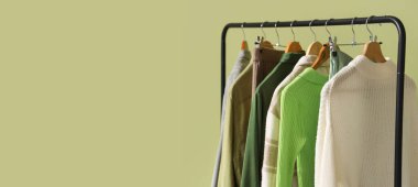 Yeşil duvarın yanında şık elbiselerle dizilin.