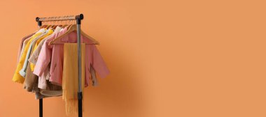 Turuncu arka planda şık çocuk kıyafetleri.